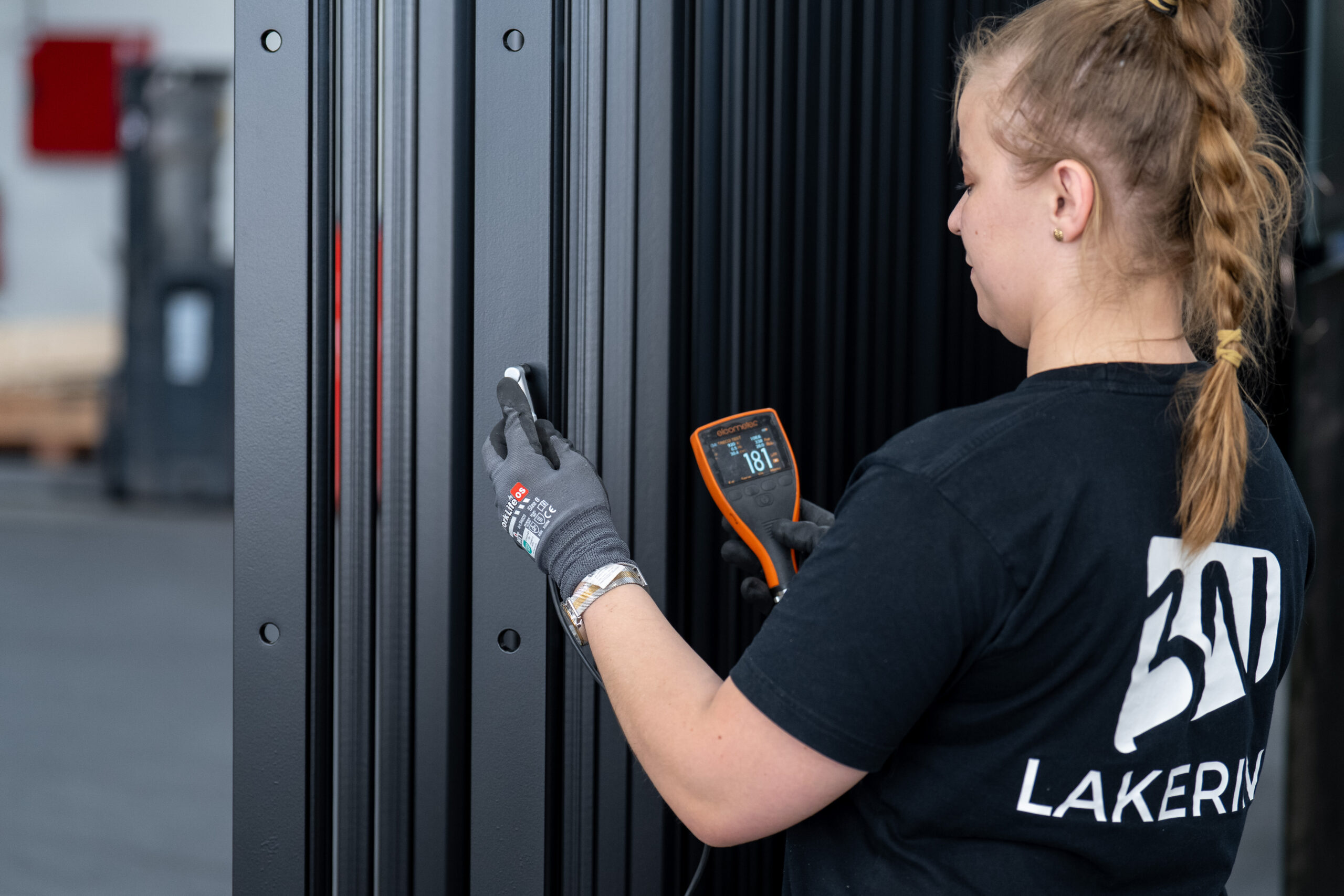 Dedekation giver kvalitet i alle lag. Koncentreret medarbejder belægger en bukket profil med blå pulverlak